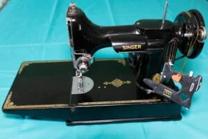 Vintage black Singer Featherweight sewing machine on a black and gold table